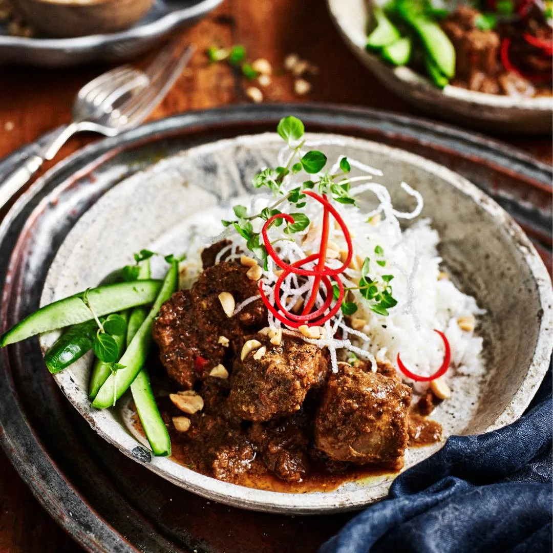 Slow cooker satay pork stew served with steamed jasmine rice and sliced cucumber