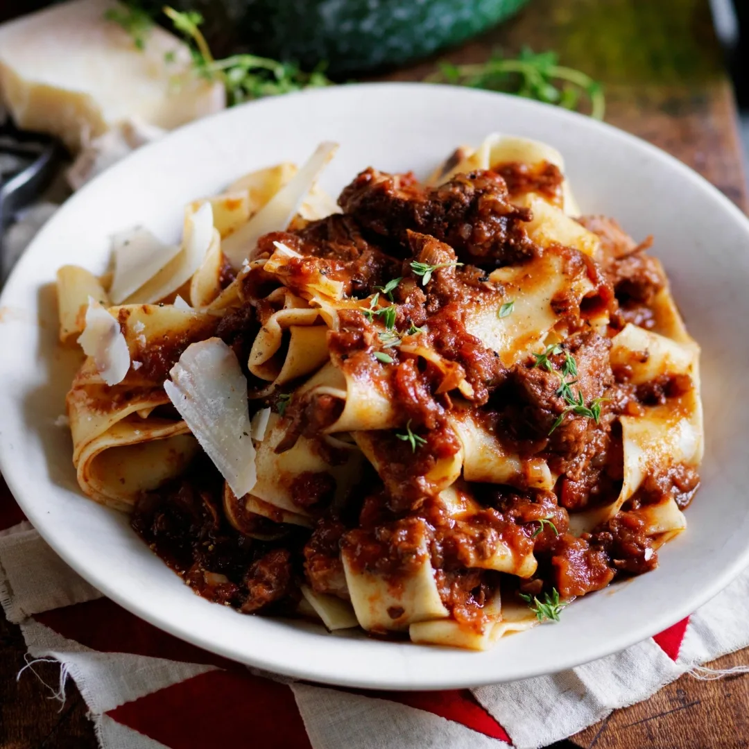 slow cooker beef ragu in a white bowl with pasta