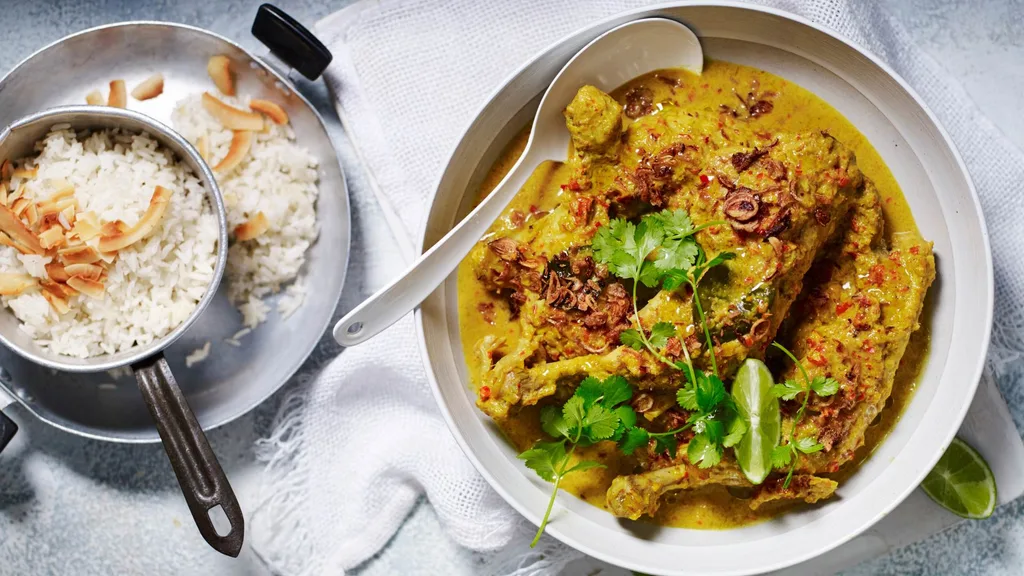 Slow cooker chicken curry served with coconut rice, fried shallots and coriander leaves