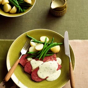 Slow cooker corned beef with horseradish sauce on a plate