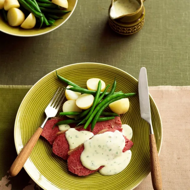 Slow cooker corned beef with horseradish sauce on a plate