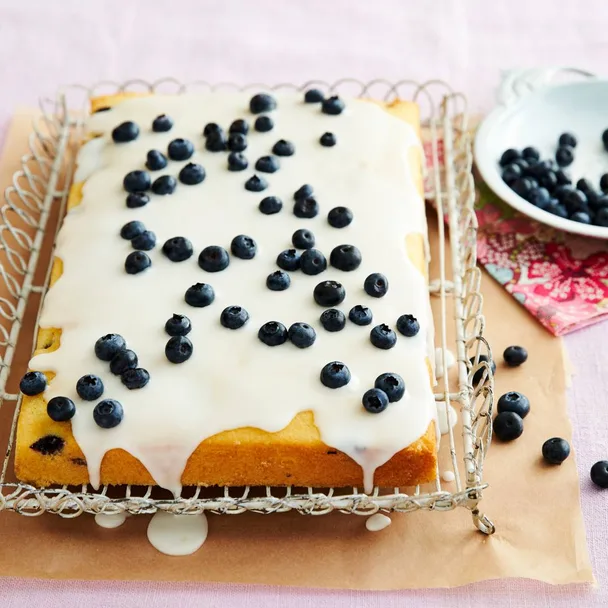 Julie Goodwin’s simple lemon blueberry cake on a cake stand with a slice missing