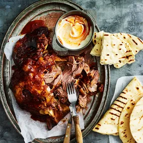 Slow cooker lamb shoulder served with a yoghurt sauce and bread