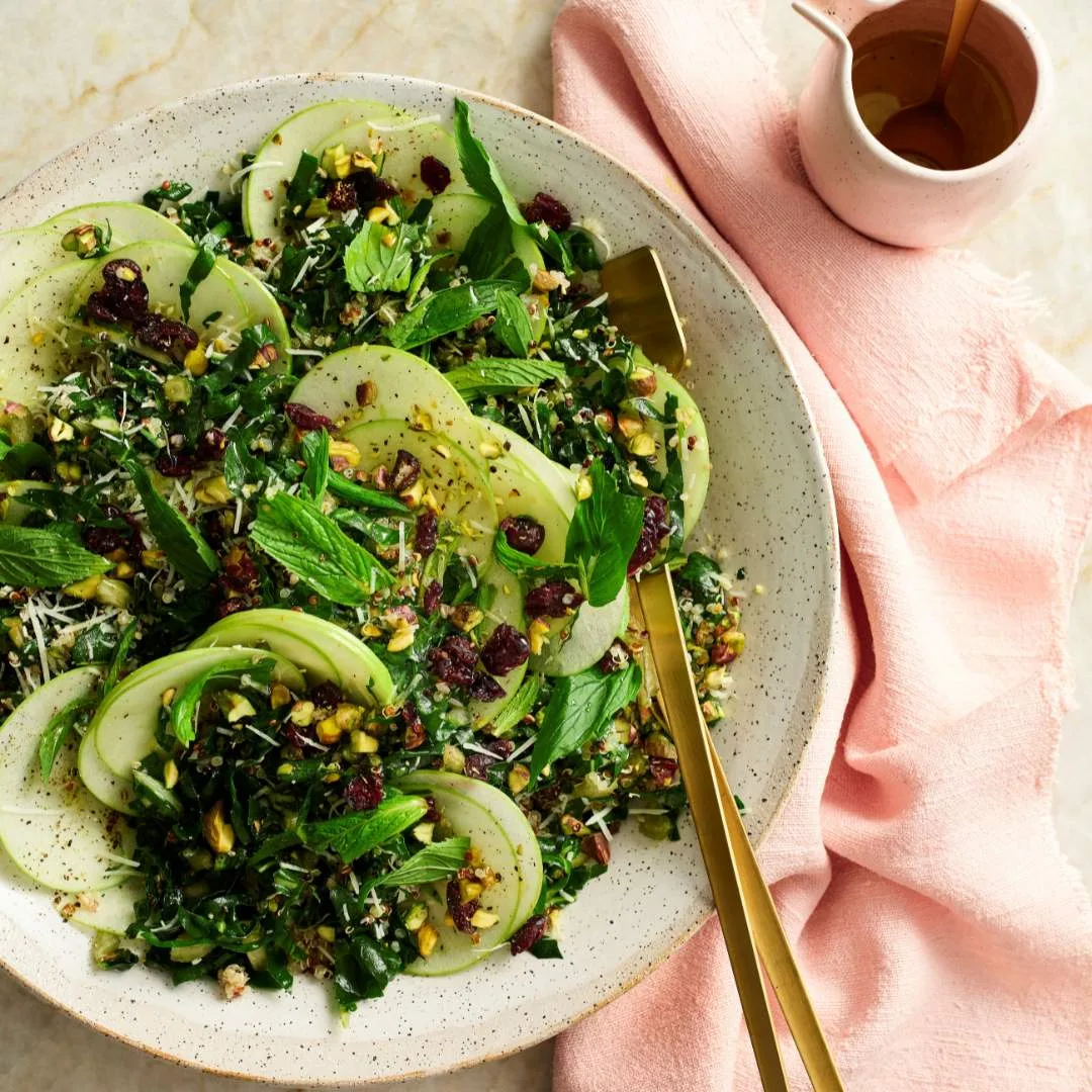 Easy apple slaw in a serving bowl with lemon honey dressing in a jug.