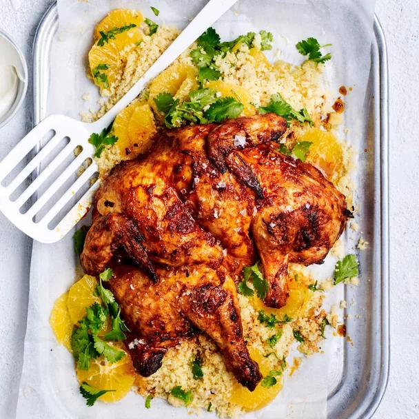 Air fryer butterflied chicken served on orange couscous