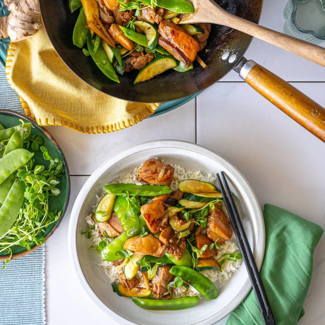 Easy chicken stir fry in a serving bowl and wok