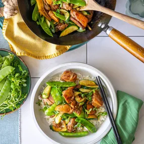 Easy chicken stir fry in a serving bowl and wok