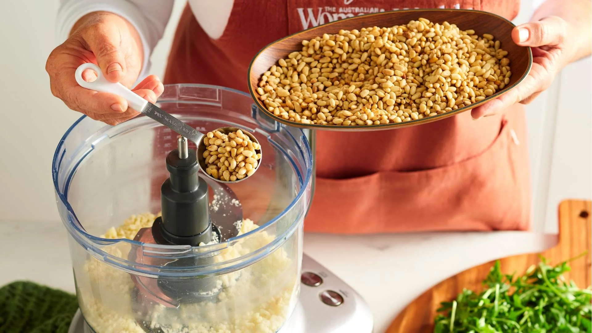 Making pesto, adding pine nuts to food processor