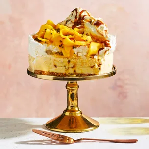 Frozen mango pavlova with passionfruit on a gold cake stand