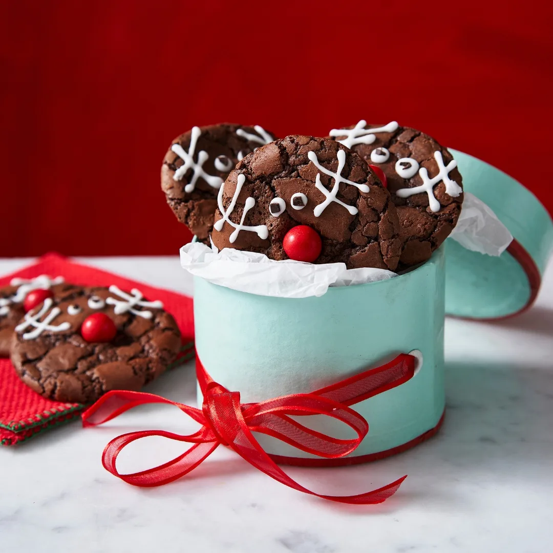 A rudolph brookie batch in a green biscuit tin wrapped with red ribbon