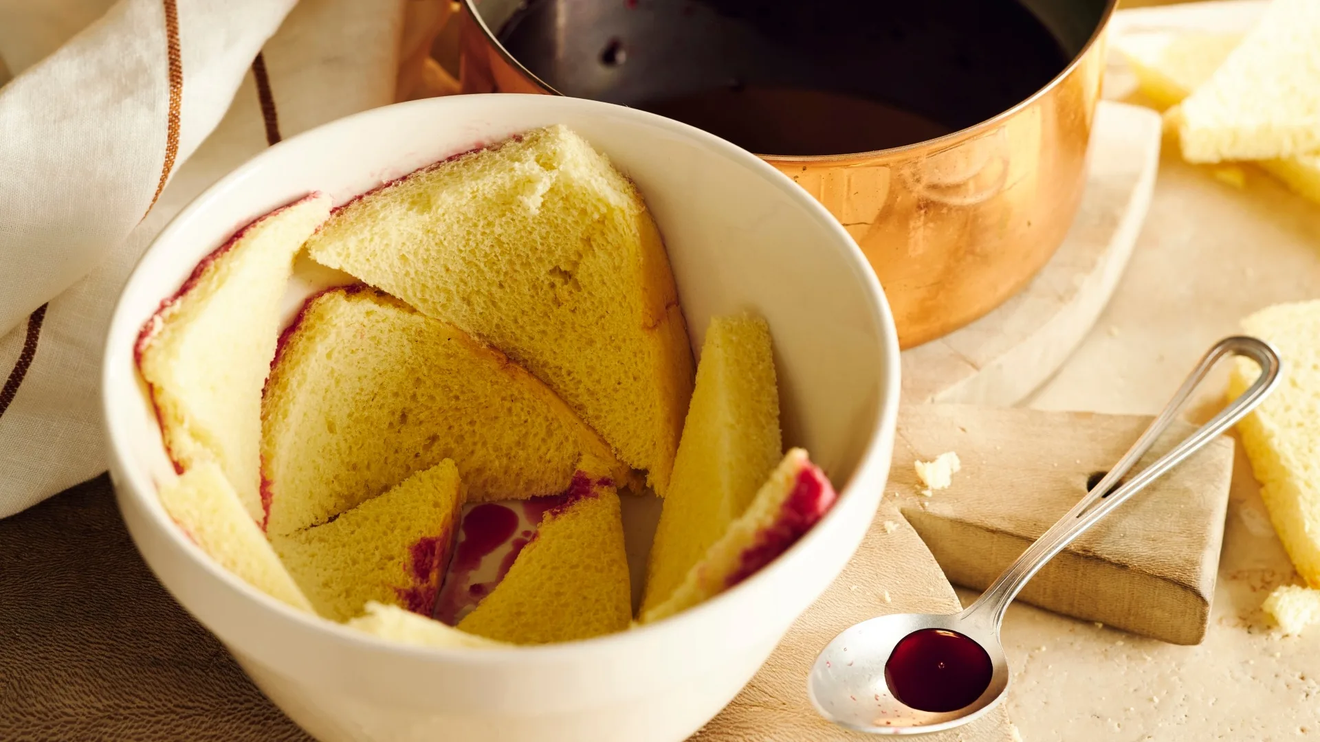 Bread slices for summer pudding arranged around the inside of a white pudding basin