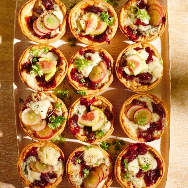 Twelve individual Maggie Beer blue cheese tarts on a serving platter