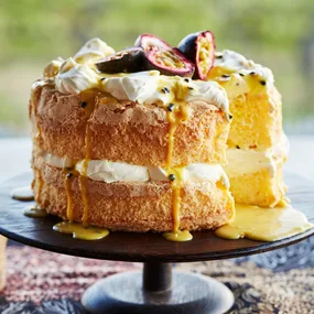 Maggie Beer’s passionfruit curd sponge cake on a dark cake stand
