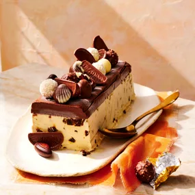 Ice cream Christmas cake loaf topped with chocolates on a platter