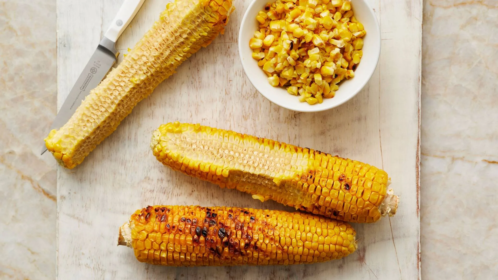 Cutting kernels off chargrilled corn