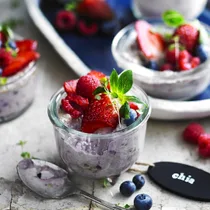 coconut chia seed pudding in a glass jar with berries on top