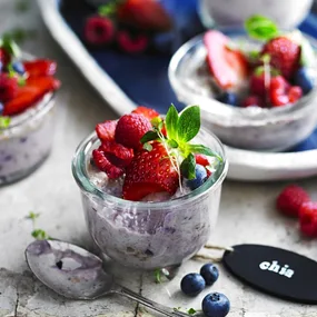 coconut chia seed pudding in a glass jar with berries on top