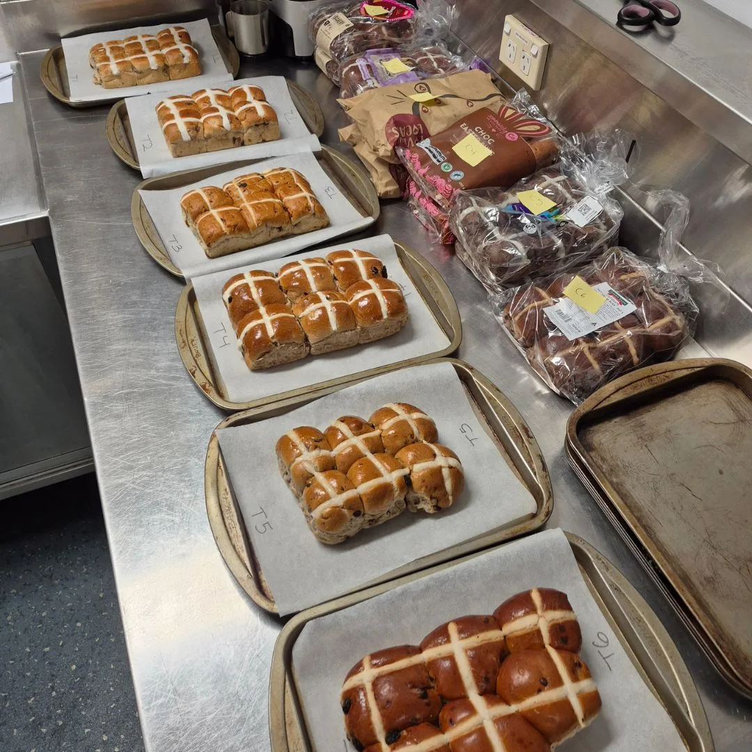 best hot cross buns taste test with buns sitting on baking trays lined with baking paper
