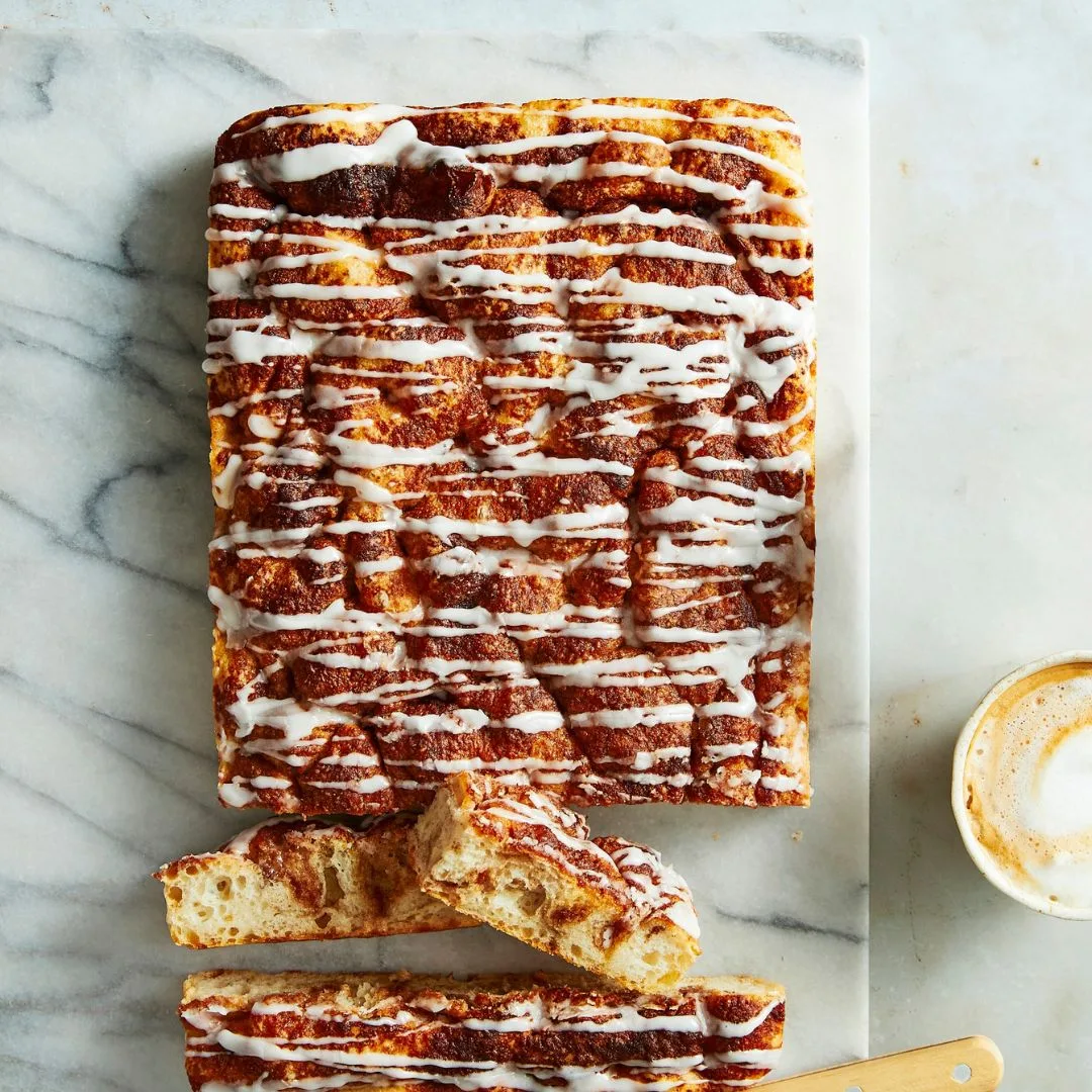 cinnamon sweet focaccia with a vanilla icing drizzled over top