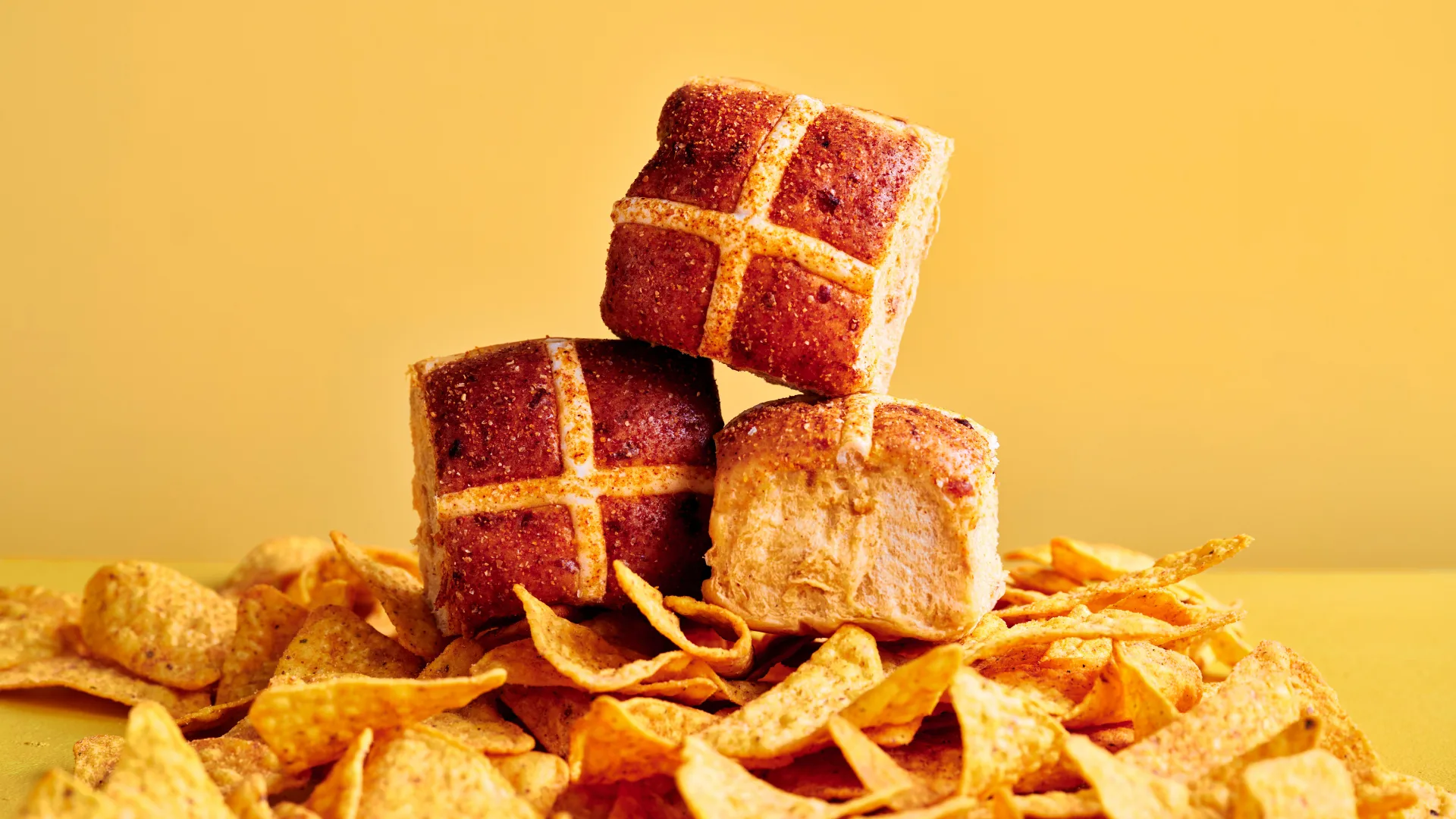 Doritos Hot Cross Buns on a pile of doritos chips in front of a yellow background
