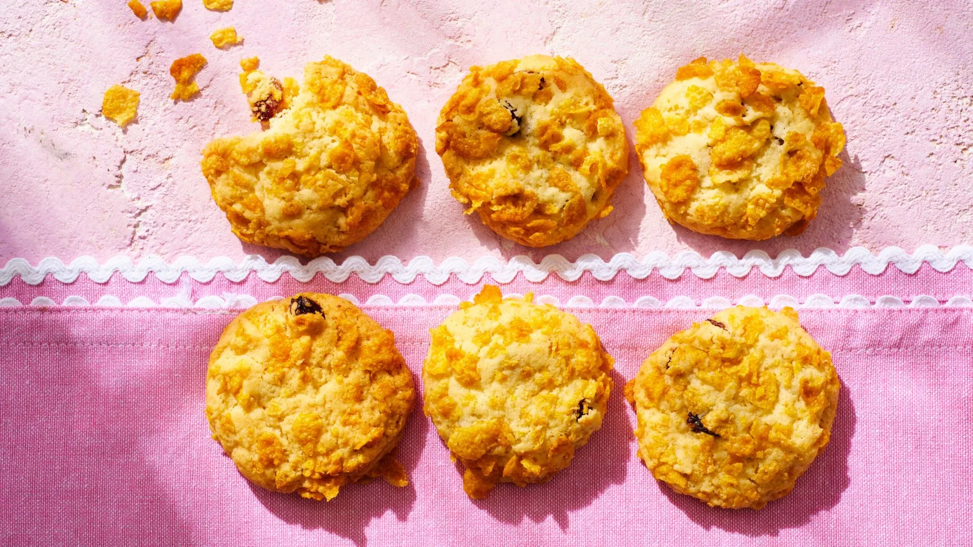 six cake mix cornflake cookies on a pink surface