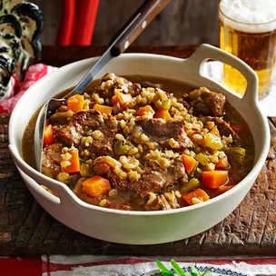 julie goodwin's slow cooked beef and barley stew in a white serving dish on a table