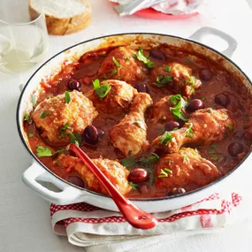 Julie Goodwin's easy chicken cacciatore in a white pan with a red spoon