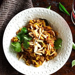 Lamb curry recipe in a white bowl on a wooden table