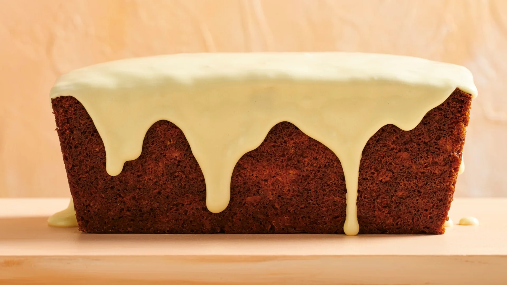 anzac loaf cake with a white icing on top and dripping down sides