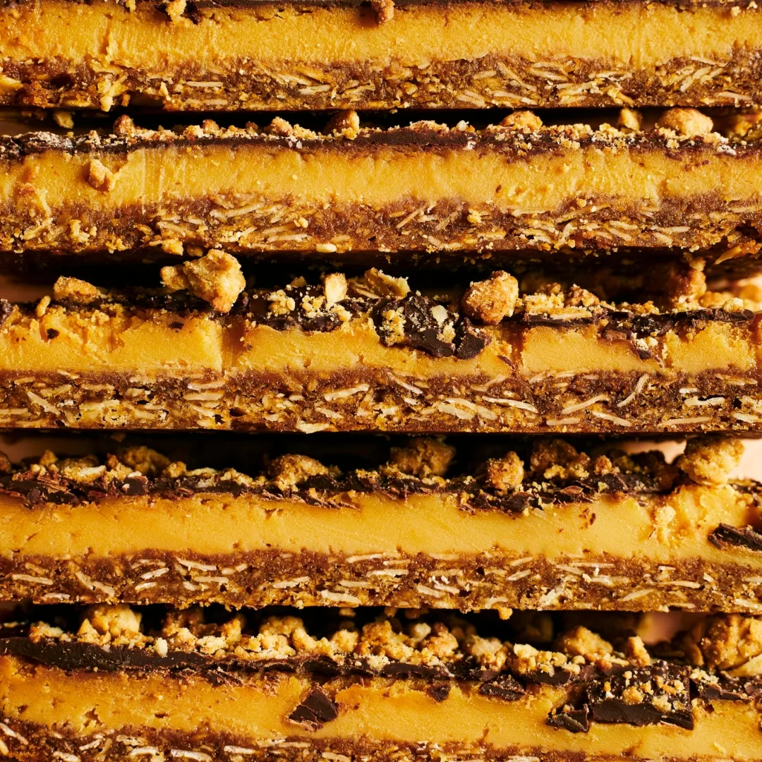 Close shot of pieces of anzac caramel slice stacked on top of each other