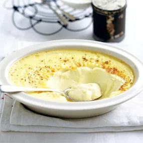 creamy baked custard in a white bowl with a spoon