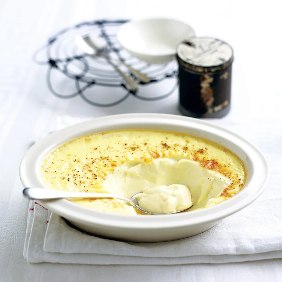 creamy baked custard in a white bowl with a spoon