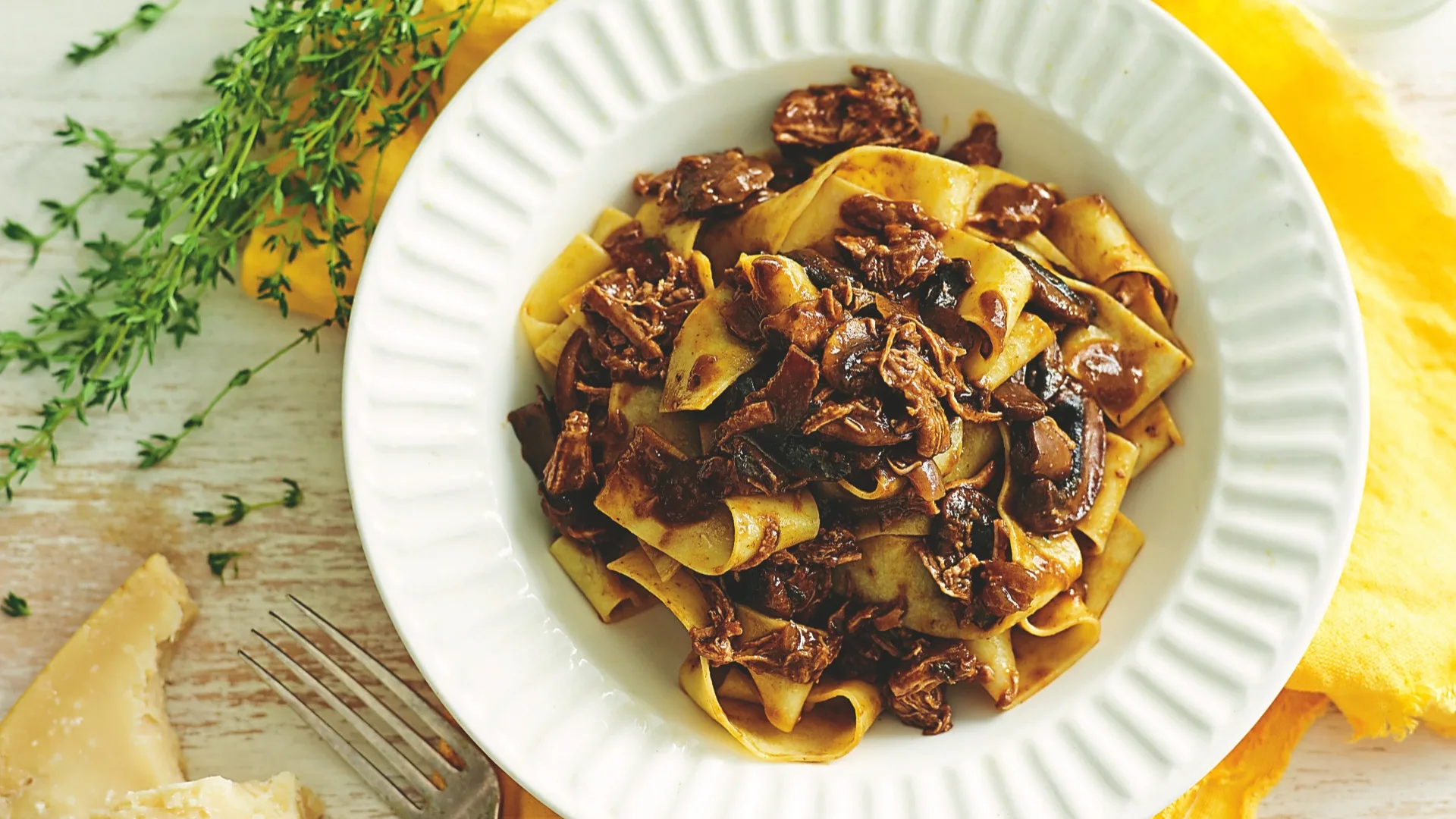 pasta with beef and mushroom ragu in a white bowl