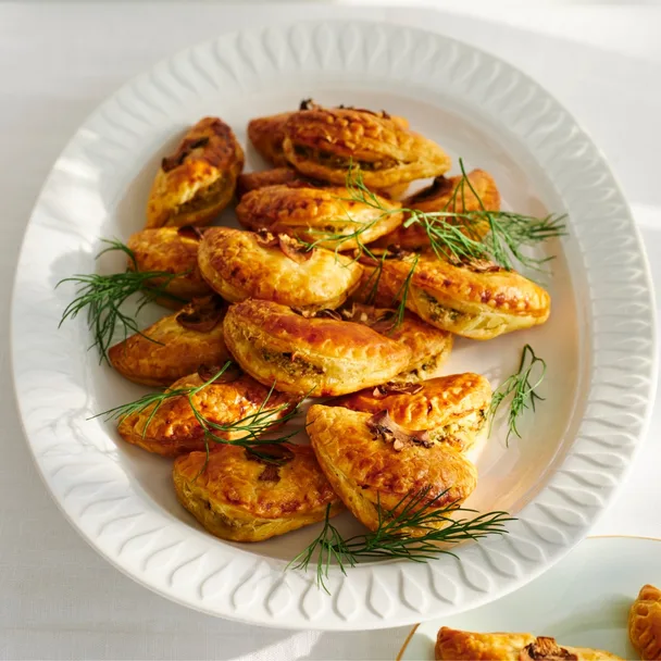 small fetta and mushroom pies on a white platter with dill