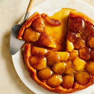 Apple tarte tatin with a slice removed and drizzled with caramel sauce