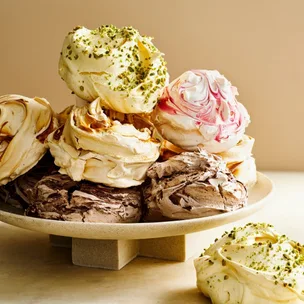 French patisserie meringues on a plate, in four different colours and flavours.