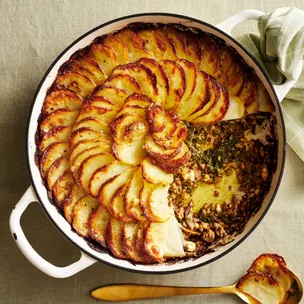 Lamb mince, silverbeet & potato pie in a round dish with a scoop taken out