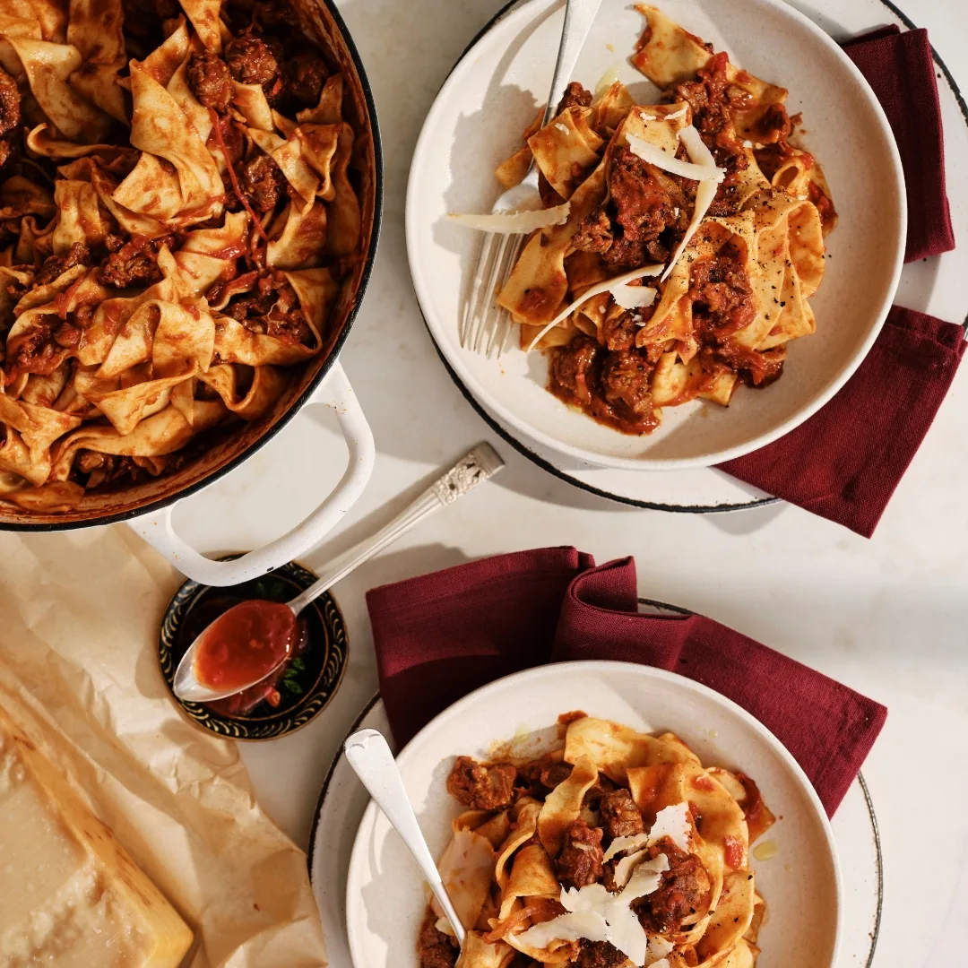 spice lamb ragu with pasta on two serving plates