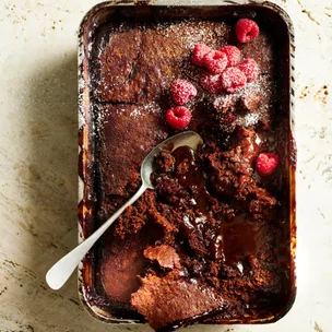mocha self-saucing pudding with raspberries and dusted with icing sugar