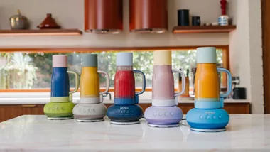 Five Ninja BlendBoss portable blenders lined up on a kitchen counter in various colourways: Cyberspace, Blue Raspberry, Watermelon Bubble Gum, Lavender Lemonade and Stone Mint.