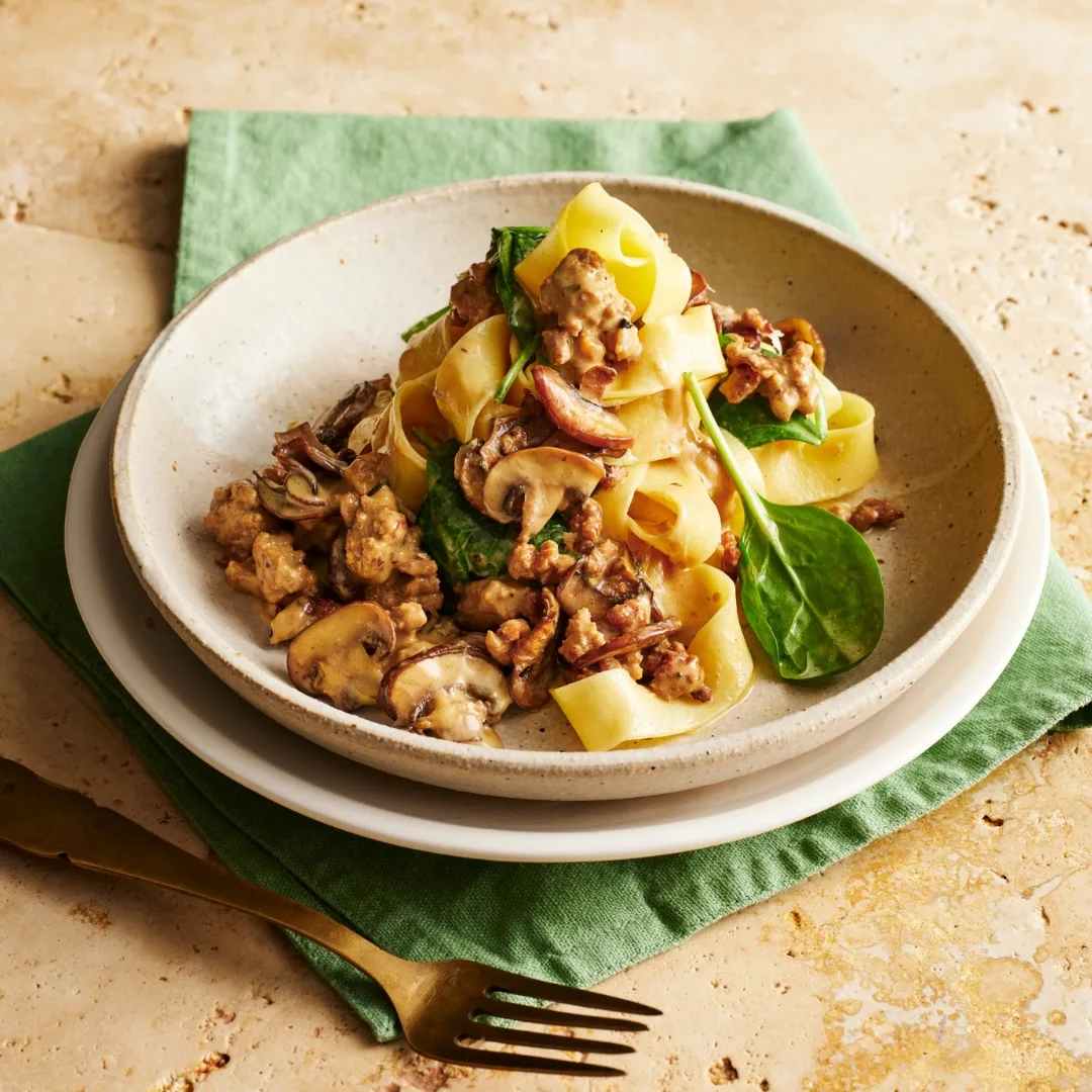 pork mince pasta with spinach and mushroom in a white bowl