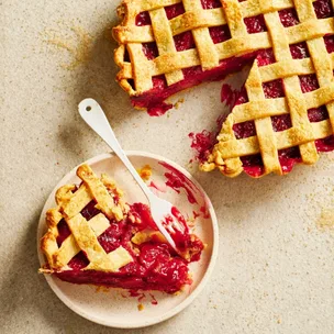 Rhubarb & apple lattice tart with one slice on a plate with a fork.