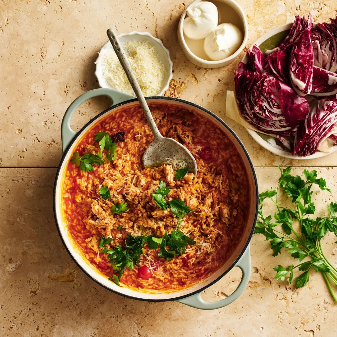 smoky tomato risotto in a large saucepan with bowls of ingredients around it