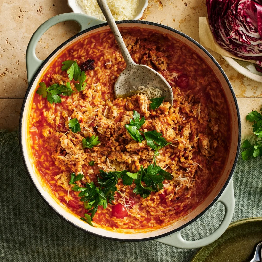 smoky tomato risotto in a large saucepan with bowls of ingredients around it