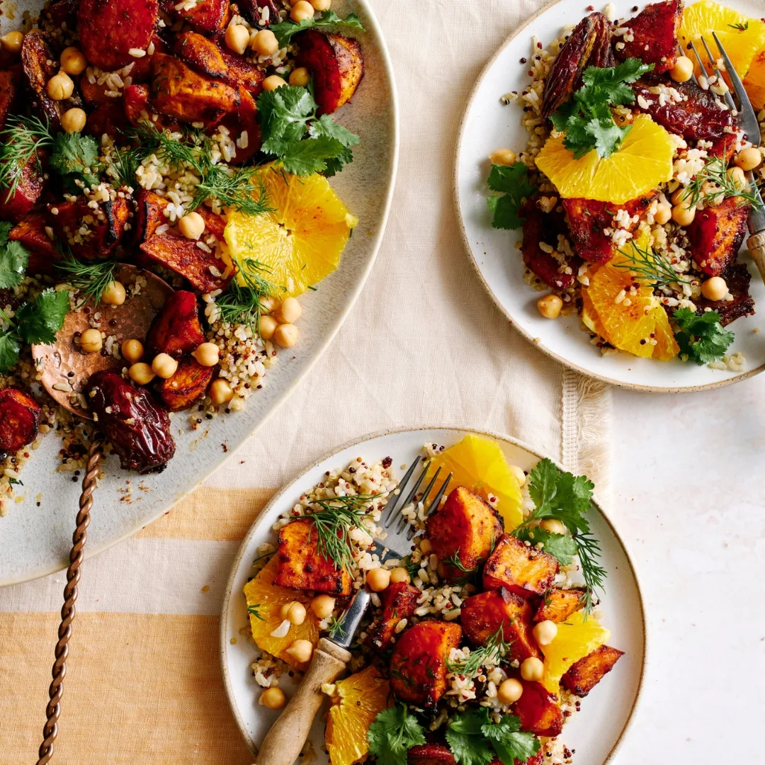 sweet potato salad on a white oval serving dish, and two white plates