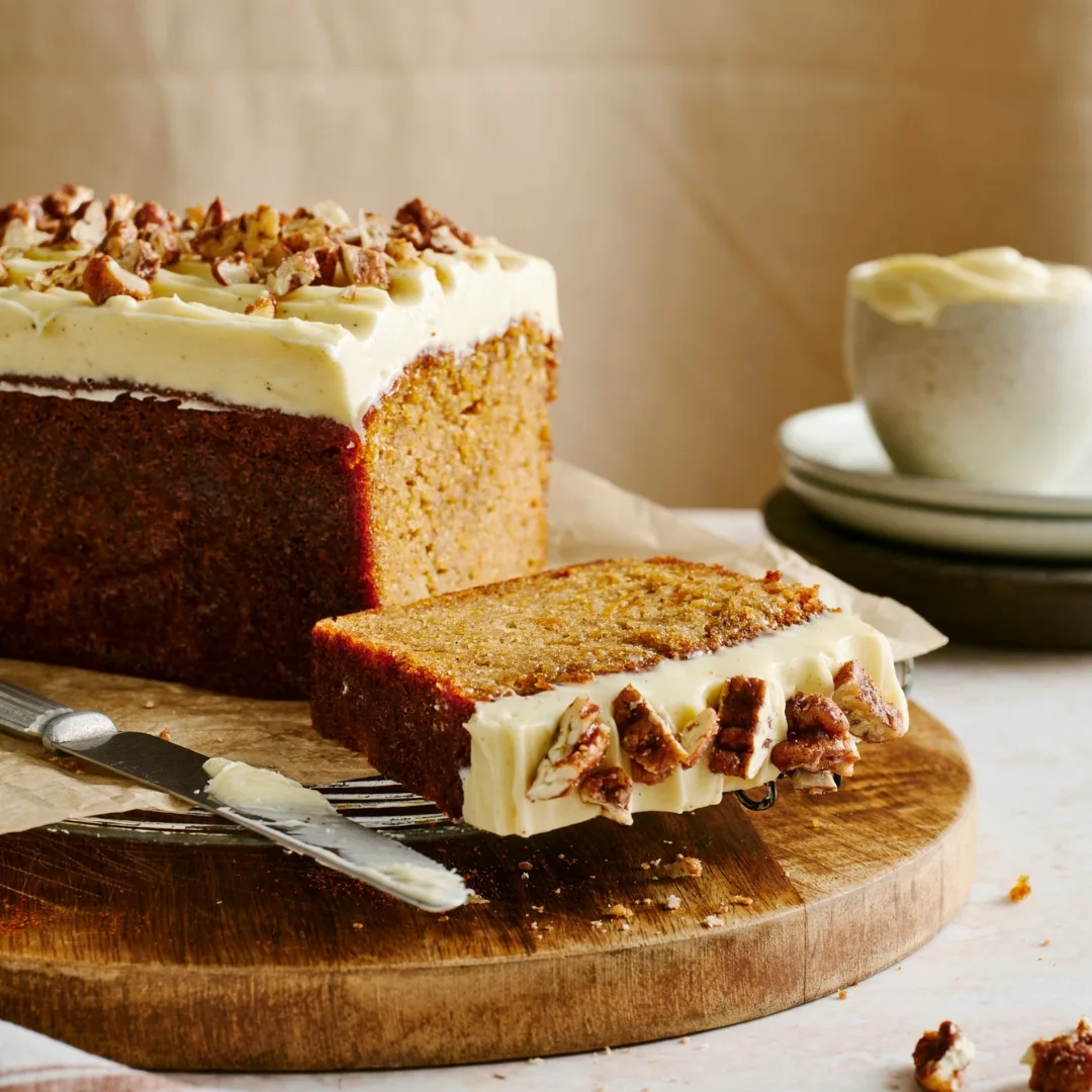 Sweet potato loaf cake on a wooden board with a slice cut