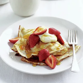 Crepes with maple syrup, strawberries, and cream
