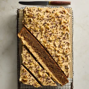 coffee sheet cake topped with icing, walnuts and cocoa nibs