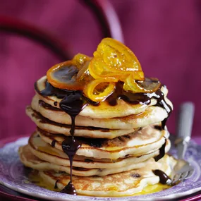 stack of orange pancakes with chocolate sauce