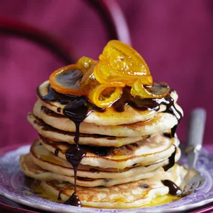 stack of orange pancakes with chocolate sauce